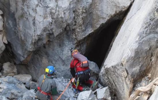 Two cave scientists are preparing to rappel down into one of the caves in the Park